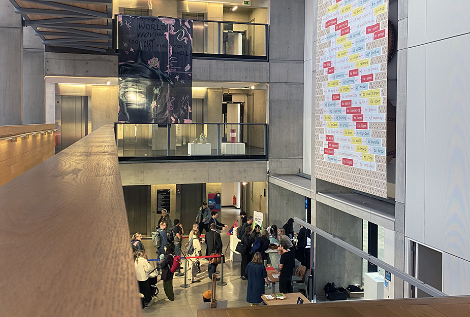 People walking into the entrance of the Design for Planet Festival 2024 at The Manchester Metropolitan University campus.