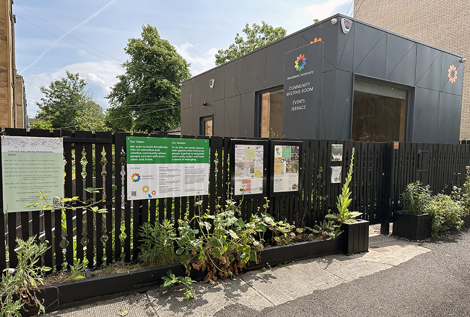 Close up of a community centre with planters by the gate.